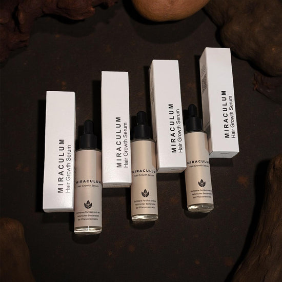 Dasifey MIRACULUM Hair Growth Serum – drei Flaschen mit Pipette und mehrere Produktboxen als Set, Flatlay auf dunklem Untergrund.
